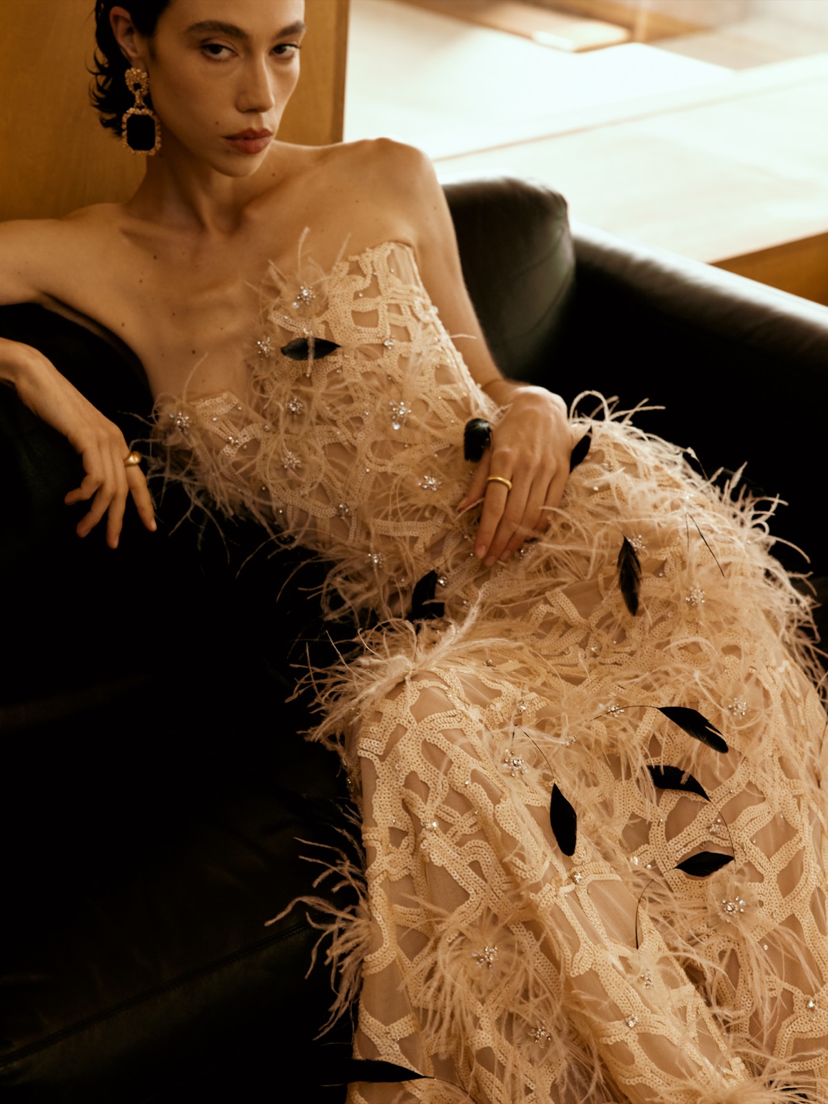 A Lichée Bridal bride in a designer feather gown, reclining in the San Francisco atelier