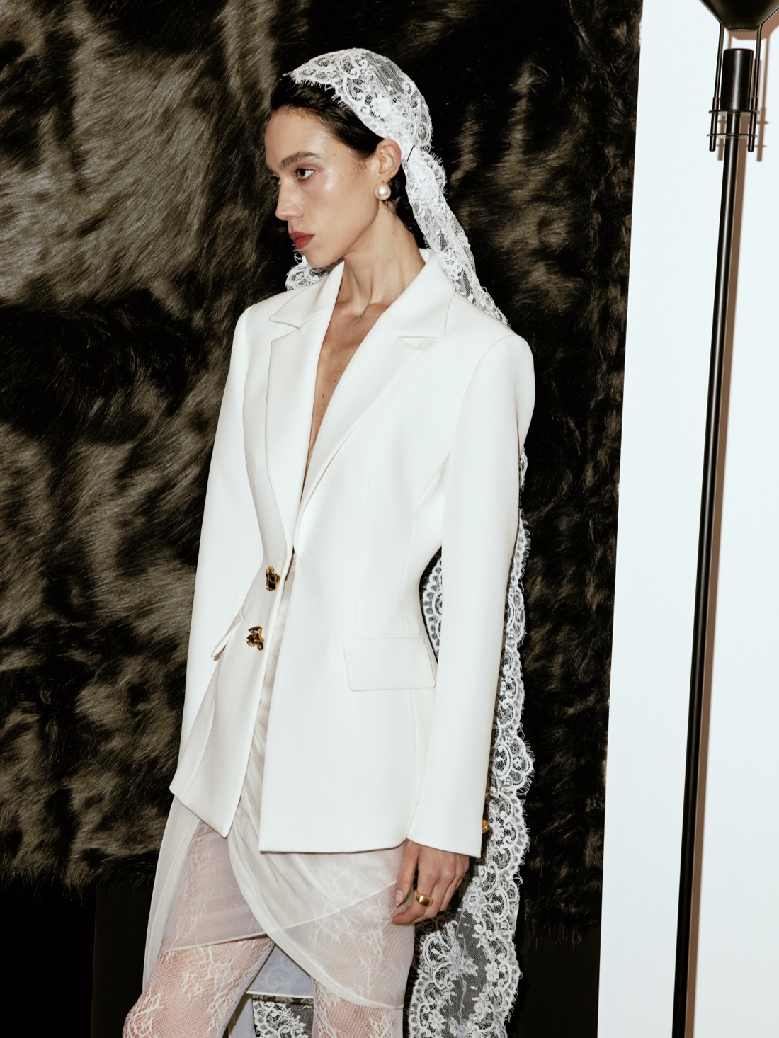 Lichée Bridal SS26 — white suit with a lace veil, in profile