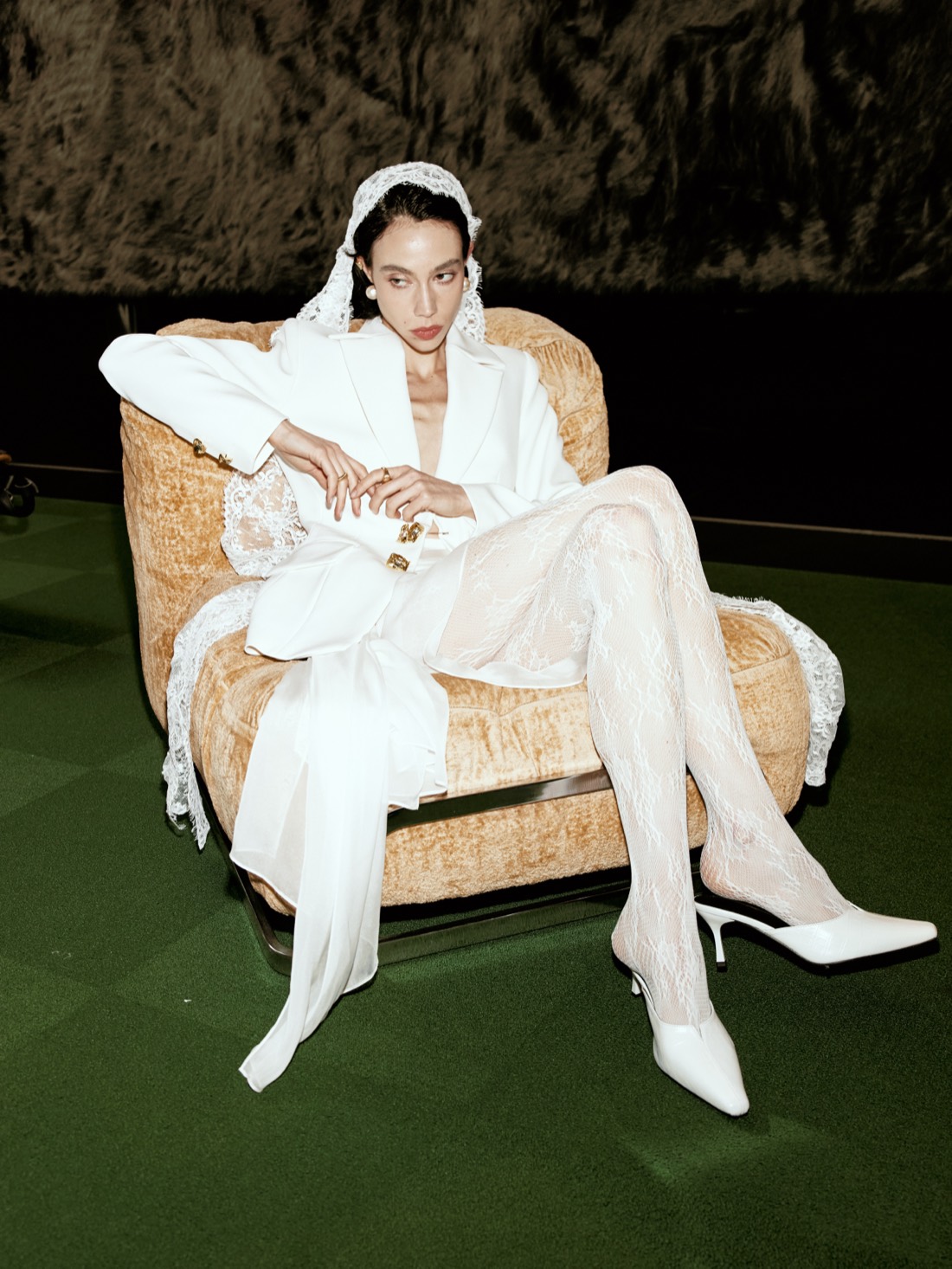 Lichée Bridal SS26 — white suit and lace tights, seated in the studio